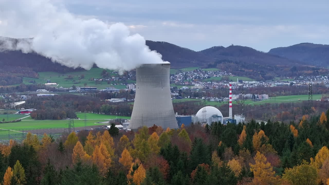Reveal drone shot of nuclear power plant G&ouml;sgen Switzerland with golden autumn trees in the foreground, drone truck 4k