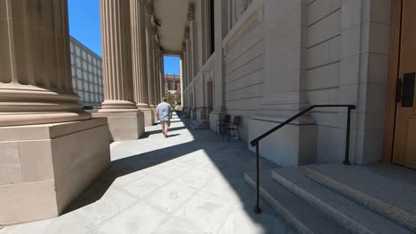 man walking on campus away from the camera