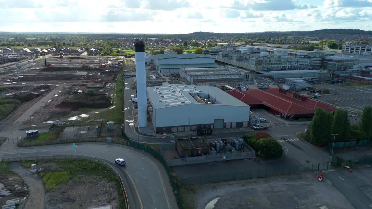 High altitude drone sweep of sprawling manufacturing plant and research labs with stacks and yard activity near Nottingham