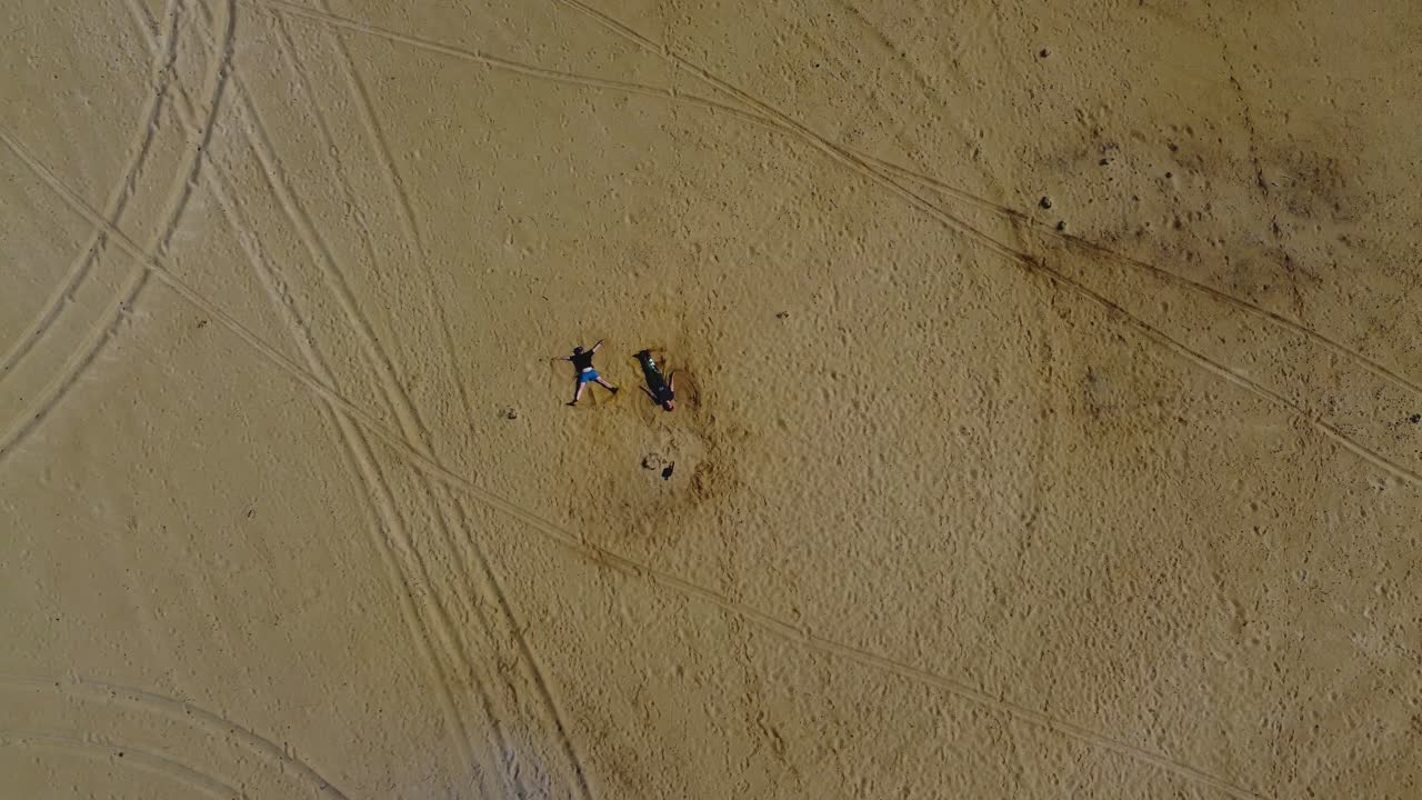 beach fun: 에스토니아의 hiiumaa 섬에서 모래 천사를 만드는 두 사람의 항공 드론 비디오 - 4k