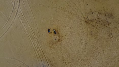 diversión en la playa: video de drones aéreos de dos tipos creando ángeles de arena en la isla de hiiumaa, estonia - 4k