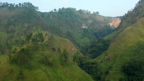 toma de drones de enfoque soleado de acantilados, selva y cascada de sipiso piso en el norte de sumatra, indonesia