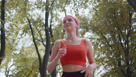 conditionnement physique sportif coureur fille entraînement marathon course, écouter de la musique dans des écouteurs dans le parc