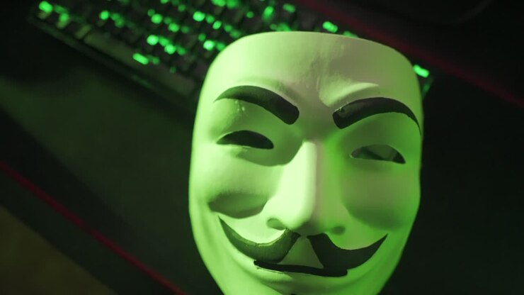 La telecamera si allontana dalla maschera di Guy Fawkes su tastiera LED.
