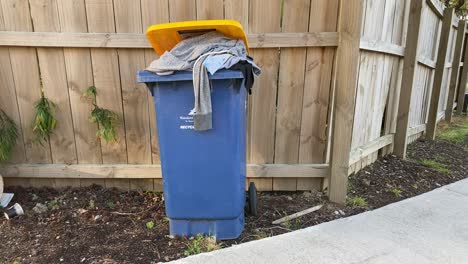 mid-shot-of-abandoned-clothes-in-the-trash-bin