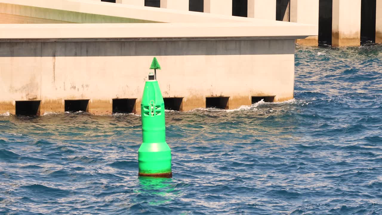 boya verde flotando cerca de una estructura de hormigón