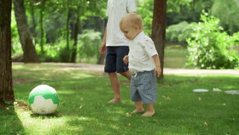 toddler and brother playing with ball. parents spending time with children