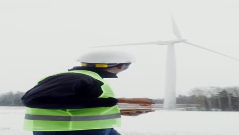 wind turbine technician inspecting in winter