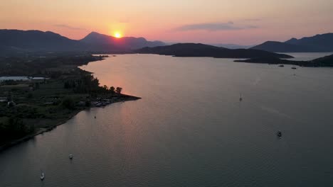 sunset over the greek saronic islands near poros while yachts and sailboats travel across the mediterranean sea