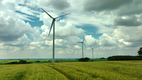 aerial footage capturing several wind turbines over green agricultural fields