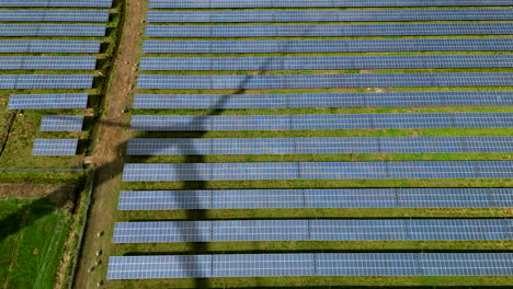 Vista-Aérea-De-Paneles-Solares-Con-Sombra-De-Una-Turbina-Eólica-Giratoria-2