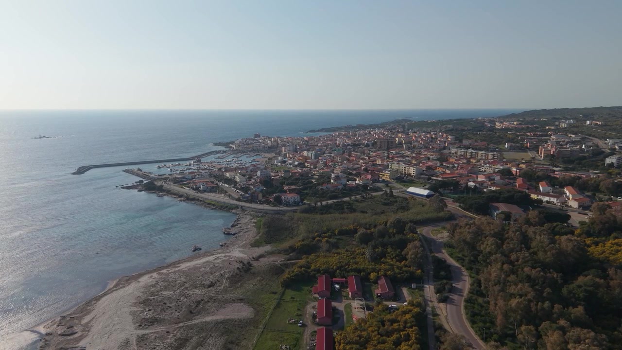 Portoscuso nel Sulcis-Iglesiente, Sardegna, Italia, che mostra la città costiera, la costa mediterranea e il paesaggio circostante - ripresa aerea.