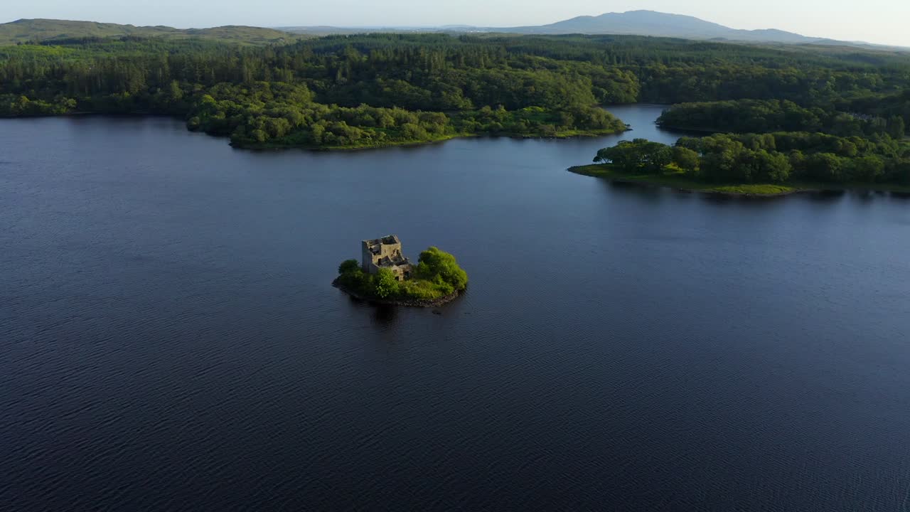 Ballynahinch Lake, Connemara, County Galway, Ireland, July 2021. Drone faces south-east while gradually descending and orbiting a small island with a ruined building