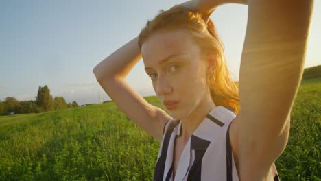 young woman in a field at sunset