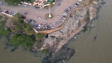 Establishing-aerial-view-looking-down-across-Colonia-del-Sacramento-Uruguay-old-city-lighthouse-bay-coastline