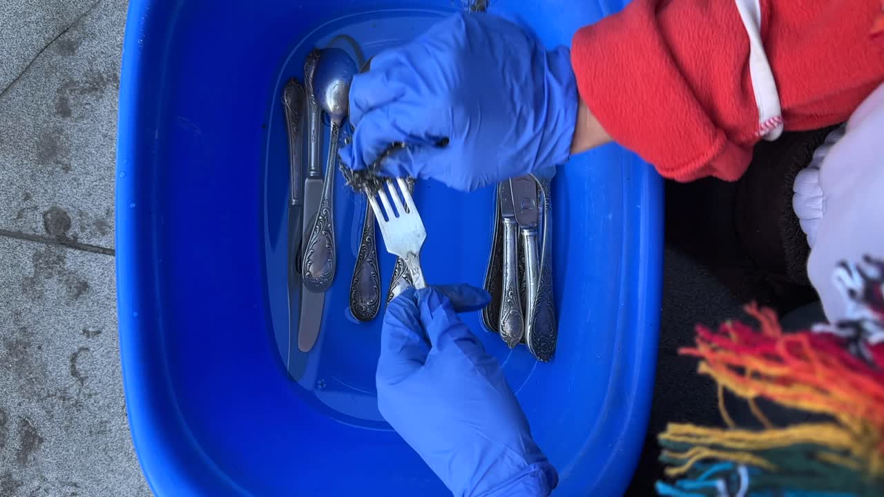 Washing Silverware in a Blue Bowl