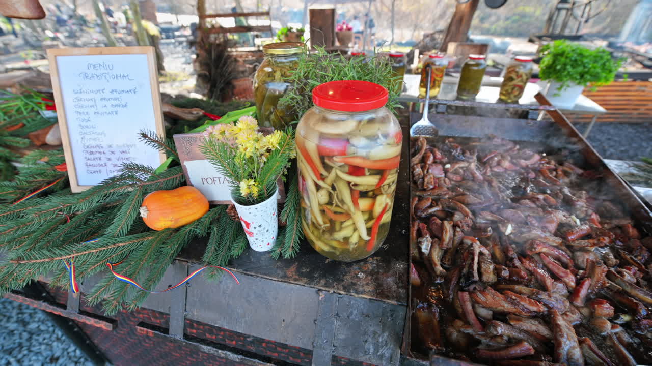 Shop with street food on the street of Sibiu, Romania. Cook cooking meat. Twigs of fir and menu on the counter