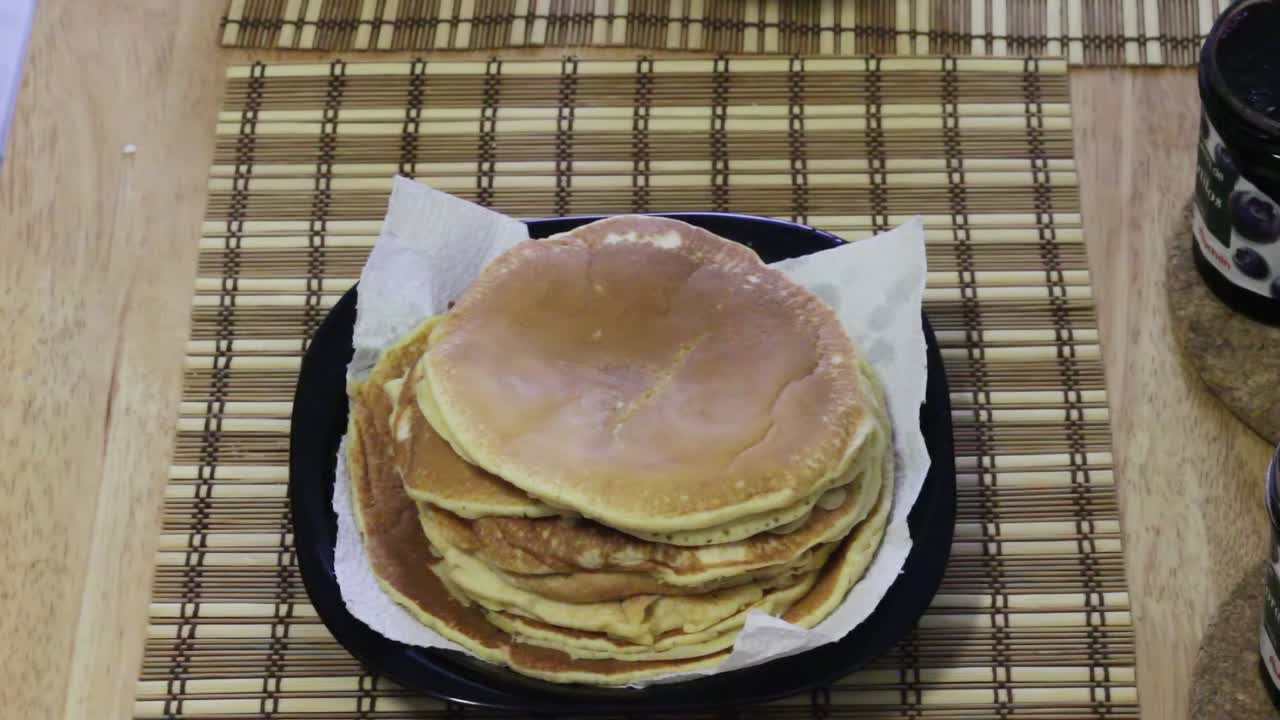 Setting Plate of Pancakes on Breakfast Table