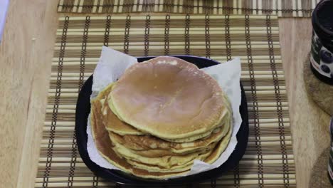 Setting Plate of Pancakes on Breakfast Table