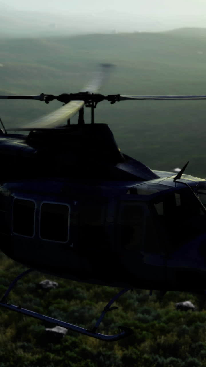 Flying over lush mountains as a helicopter hovers in the golden light of dusk