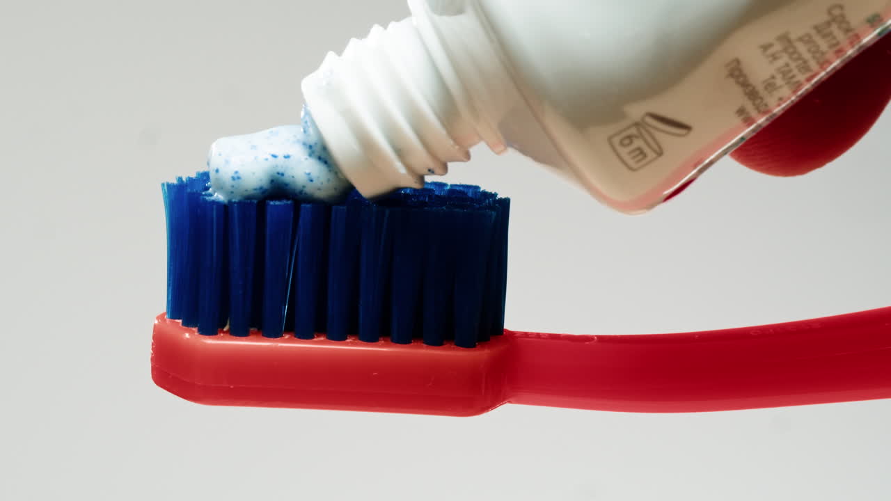 la aplicación de pasta de dientes a un cepillo de dientes