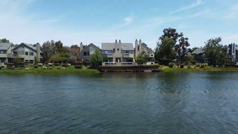 drone rising up from blue lagoon towards san mateo parkside aquatic park , beautiful villas, california