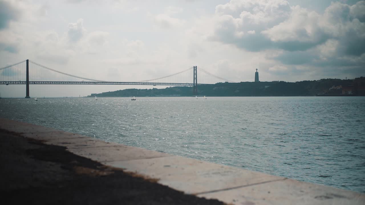 리스본의 구름 은 타구스 강과 4월 25일 다리, 배경에는 항해 보트가 있다.