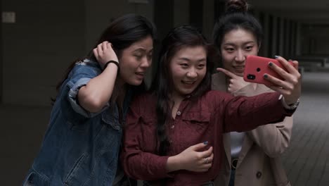 portrait of a group of asian women friends taking a selfie with a mobile phone together.