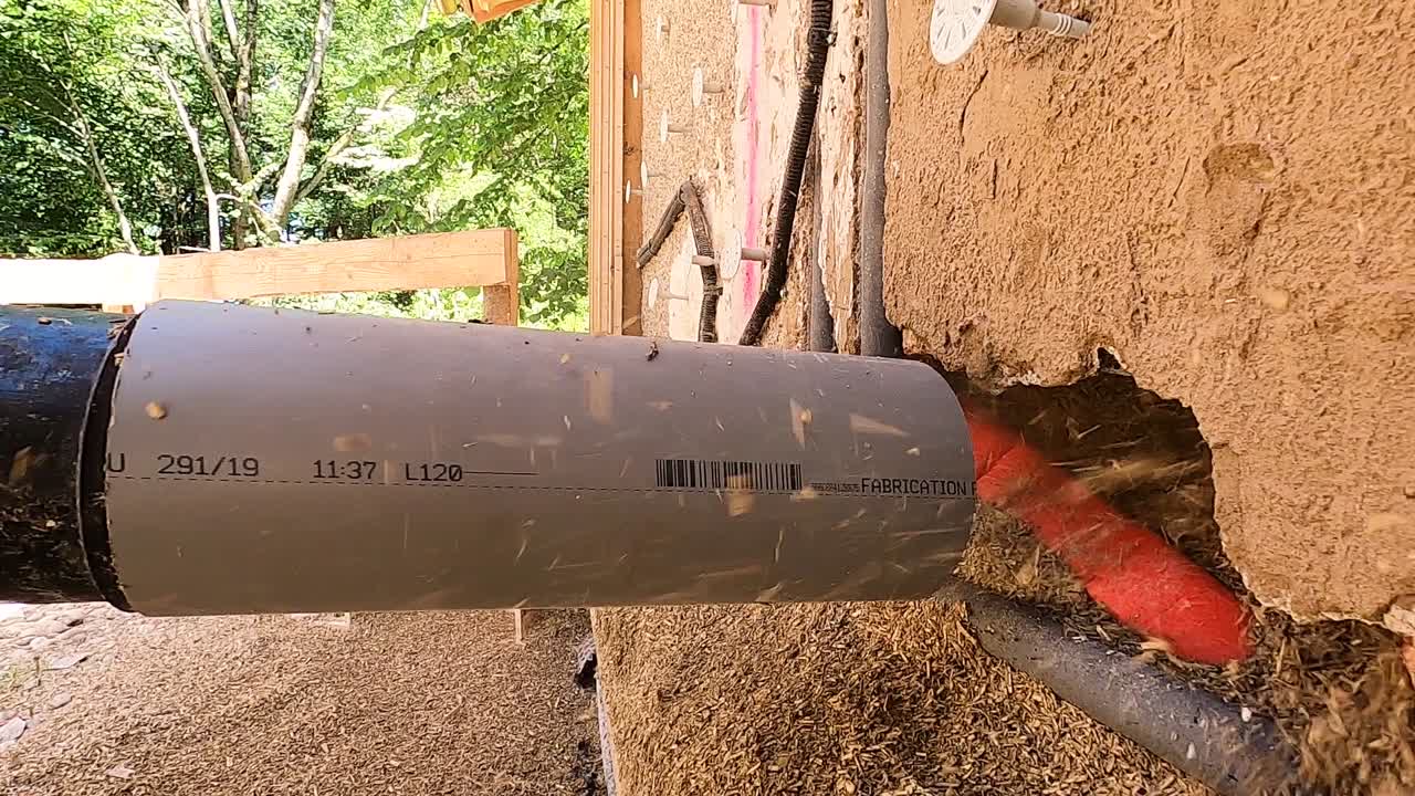 primer plano de un hombre rociando hempcrete en una pared en un sitio de construcción