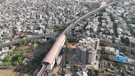 Daytime aerial showing organized traffic, green spaces, and wide roads in Jaipur