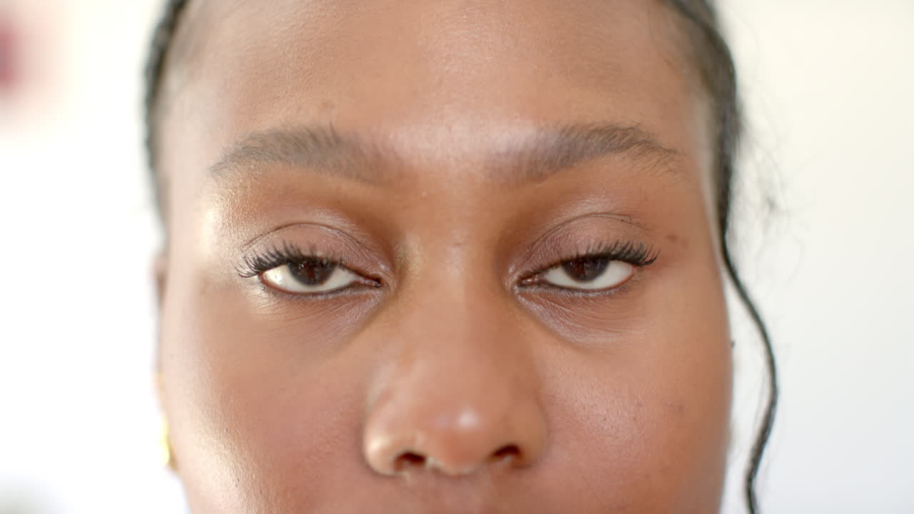 A young African American woman with brown eyes is looking forward at home, at home