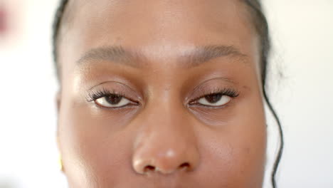 a young african american woman with brown eyes is looking forward at home, at home