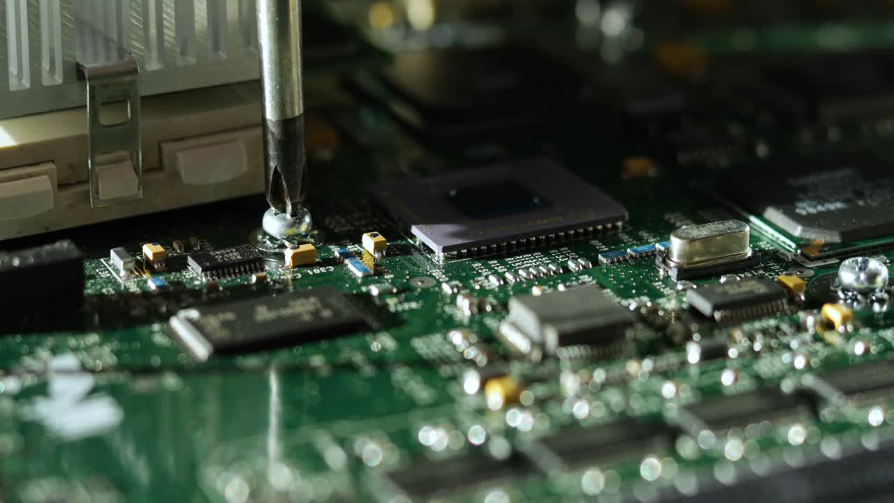 Close-up of tightening a screw on a computer motherboard.
