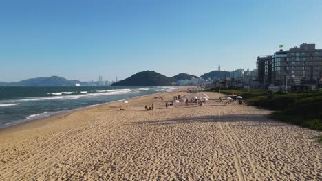 drone view of praia brava in brazil with buildings on the back