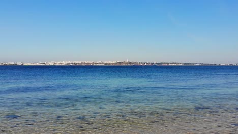 drone shot from the water line at the beach on troia with a view to setubal