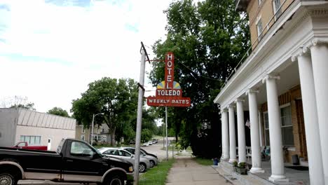 Letrero-Del-Hotel-De-Toledo-En-El-Centro-De-Toledo,-Iowa,-Con-Un-Video-De-Cardán-Caminando-Hacia-Adelante