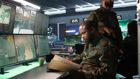 especialista del ejército que supervisa las operaciones de seguridad nacional, leyendo archivos de carpeta