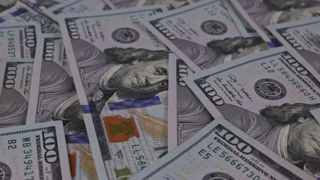 Pila di banconote da cento dollari in primo piano.