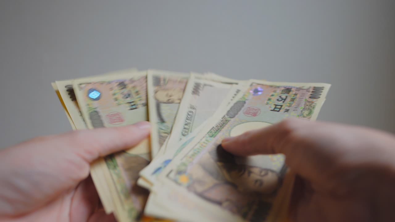 일본 통화를 들고 있는 누군가의 손 샷