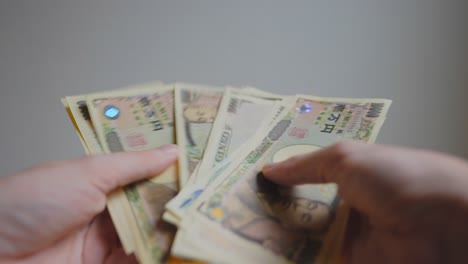 Shot-of-someone's-hands-holding-some-Japanese-currency