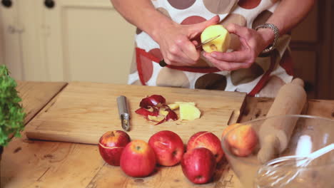 cerca de las manos pelando y cortando una manzana