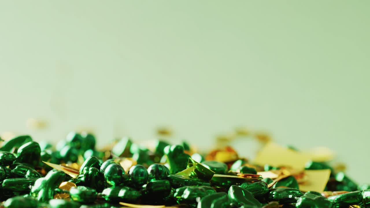 Video of st patrick's green necklace and gold sequins on green background