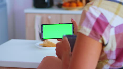 woman watching a phone with green screen