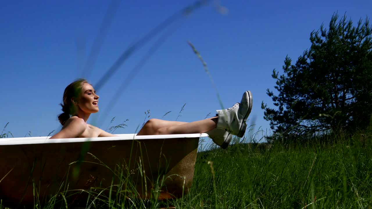 욕조에 있는 멋진 소녀는 즐겁고 편안합니다.