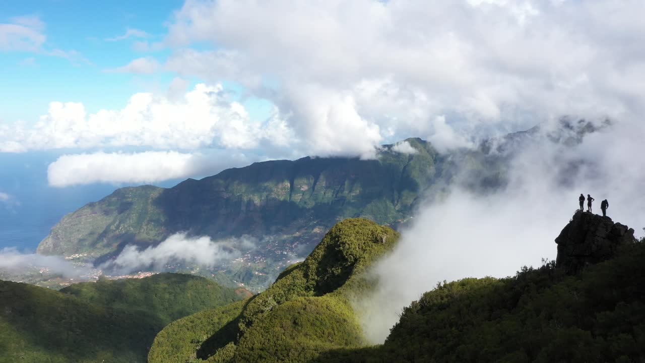3 friends standing on the edge looking over the epic landscape of Sao Vicente during Monte Trigo hike