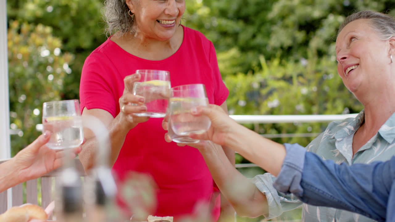 grupo diverso de mujeres mayores disfrutando de un brindis al aire libre