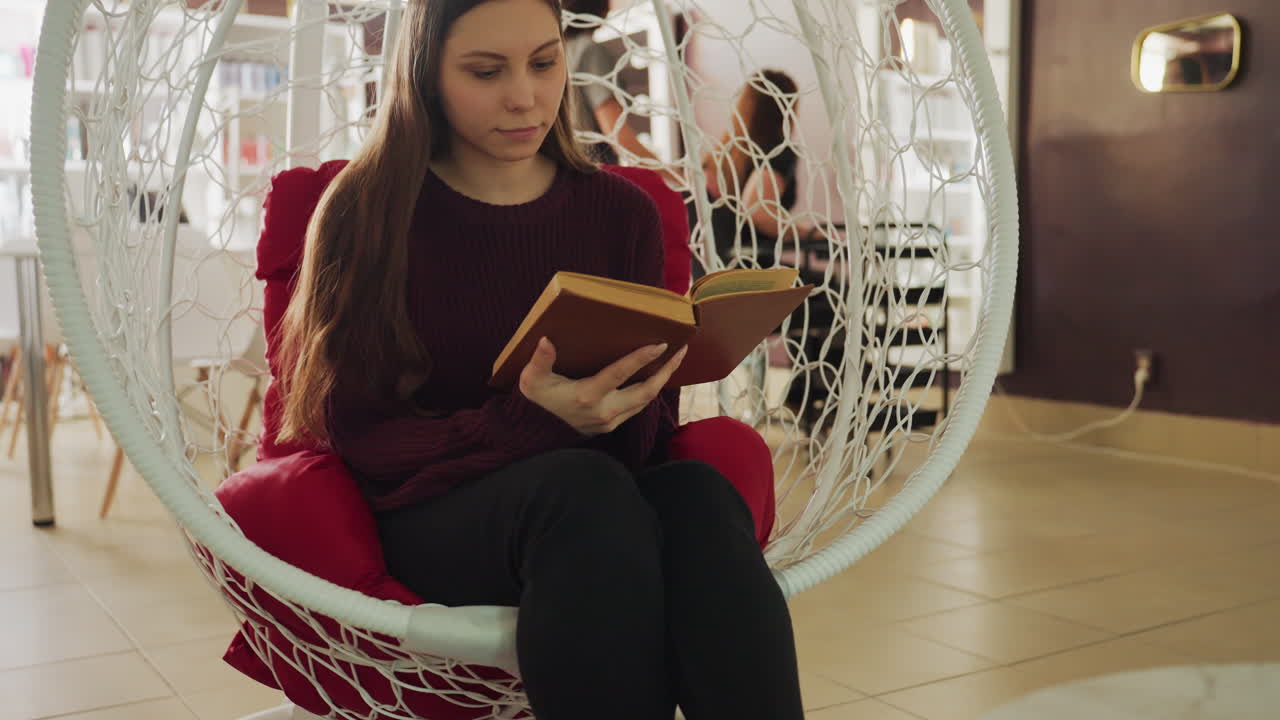 Preciosa colección de libros vintage expuesta, primer plano de libros antiguos apilados en un acogedor entorno de librería, que muestra literatura clásica con cómodos asientos en una tienda cálidamente decorada