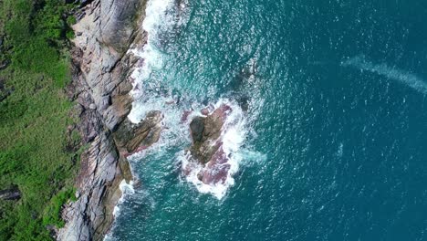 aerial view drone camera top down of seashore rocks in a blue ocean beautiful sea surface amazing sea waves crashing on rocks seascape aerial view drone 4k high quality of ocean with stone rock cliff