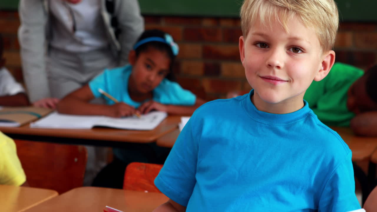 niño sonriendo a la cámara durante la clase