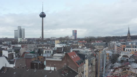 Forwards-fly-above-apartment-buildings-in-urban-neighbourhood.-Tall-and-slim-Colonius-telecommunications-tower.-Cologne,-Germany